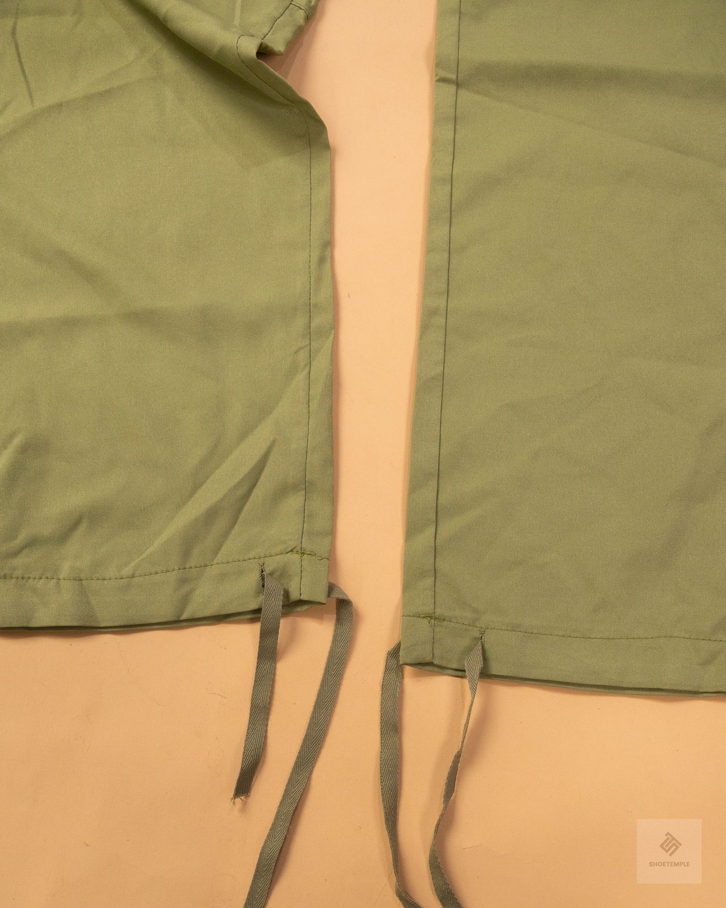 khaki green cargo pants featuring side pockets, a drawstring waist, and adjustable ankle ties