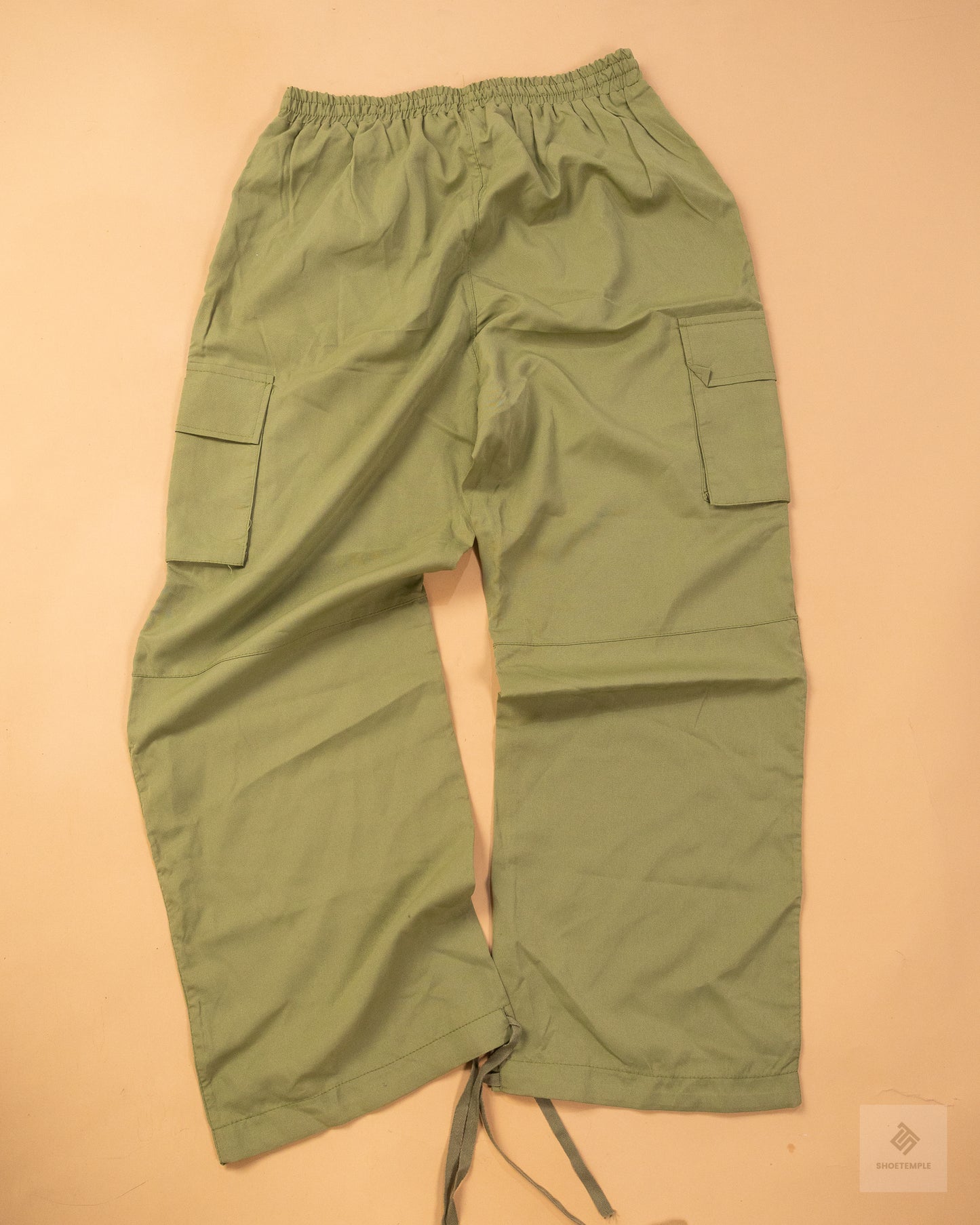 khaki green cargo pants featuring side pockets, a drawstring waist, and adjustable ankle ties